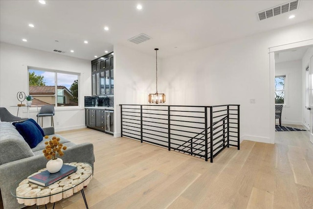 interior space with a chandelier, light hardwood / wood-style flooring, and beverage cooler