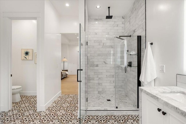 bathroom with tile patterned floors, walk in shower, vanity, and toilet