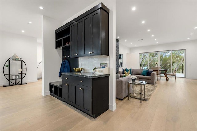 kitchen with light wood-type flooring and backsplash