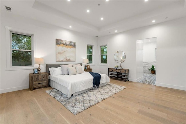 bedroom with light wood-type flooring and multiple windows