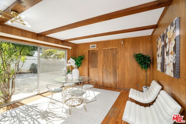 sunroom / solarium featuring beam ceiling and an inviting chandelier