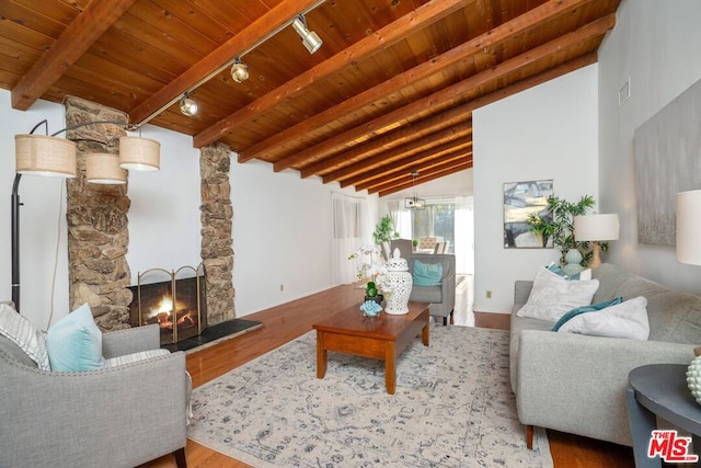 living room featuring track lighting, wood ceiling, hardwood / wood-style flooring, a fireplace, and vaulted ceiling with beams