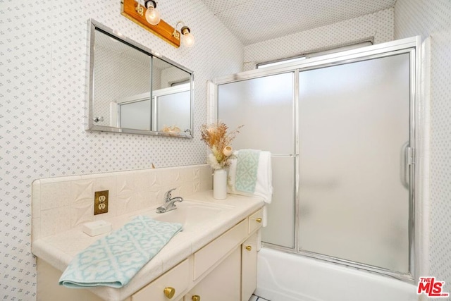 bathroom featuring shower / bath combination with glass door, vanity, and vaulted ceiling