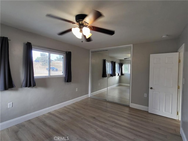 unfurnished bedroom with ceiling fan, a closet, and hardwood / wood-style floors