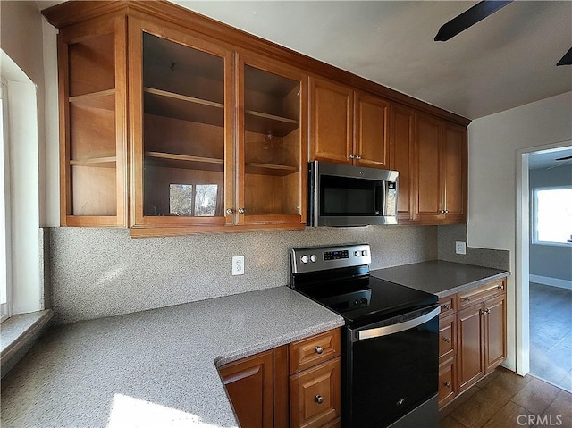 kitchen with tasteful backsplash, stainless steel appliances, ceiling fan, and dark wood-type flooring