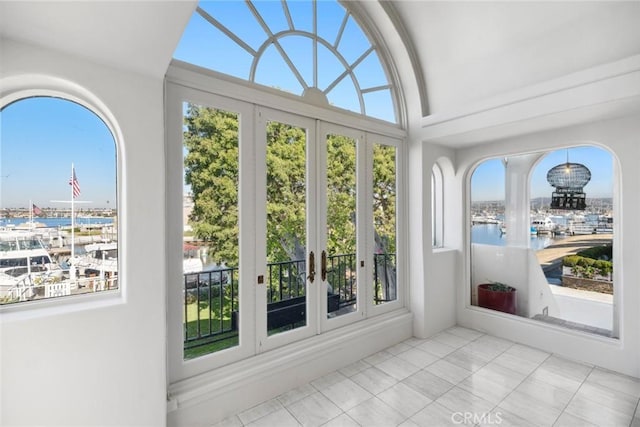 unfurnished sunroom with french doors, a water view, and vaulted ceiling