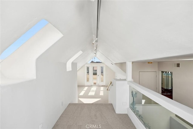 hallway with light colored carpet and vaulted ceiling