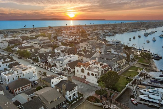 aerial view at dusk featuring a water view