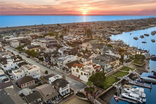 aerial view at dusk featuring a water view