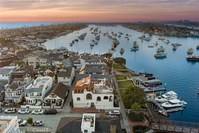 aerial view at dusk featuring a water view