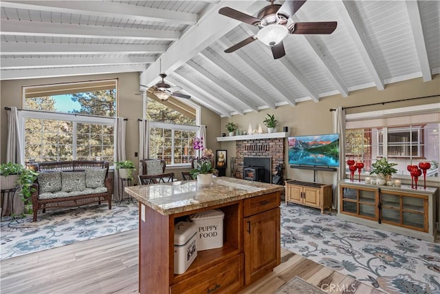 sunroom / solarium with ceiling fan and vaulted ceiling with beams