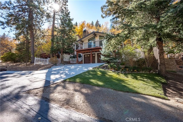 view of front facade featuring a garage, a deck, and a front lawn