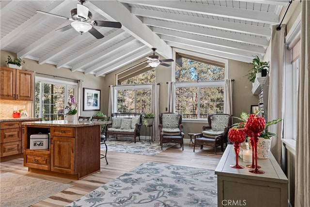 sunroom featuring vaulted ceiling with beams and ceiling fan