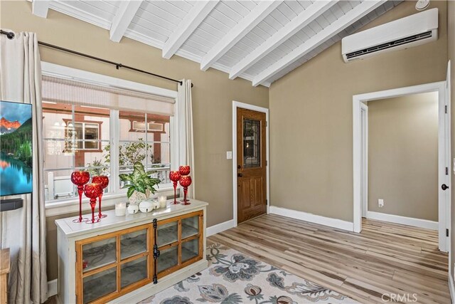 interior space featuring light wood-type flooring, wooden ceiling, lofted ceiling with beams, and an AC wall unit