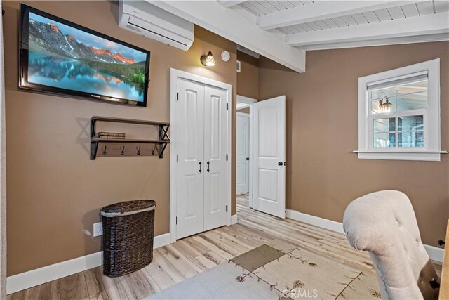 interior space featuring wood ceiling, light wood-type flooring, a wall unit AC, and vaulted ceiling with beams