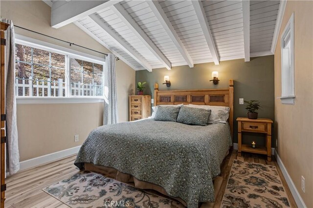 bedroom featuring hardwood / wood-style floors and vaulted ceiling with beams