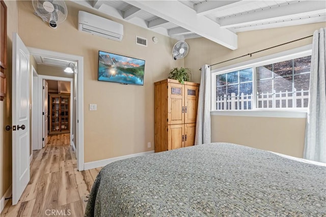 bedroom featuring an AC wall unit, vaulted ceiling with beams, and light hardwood / wood-style flooring