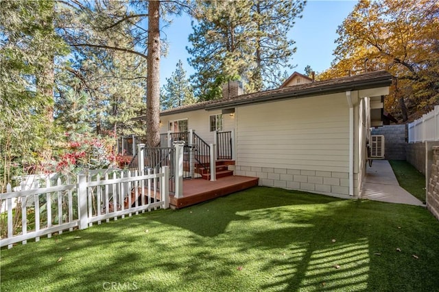 back of property featuring a deck and a lawn