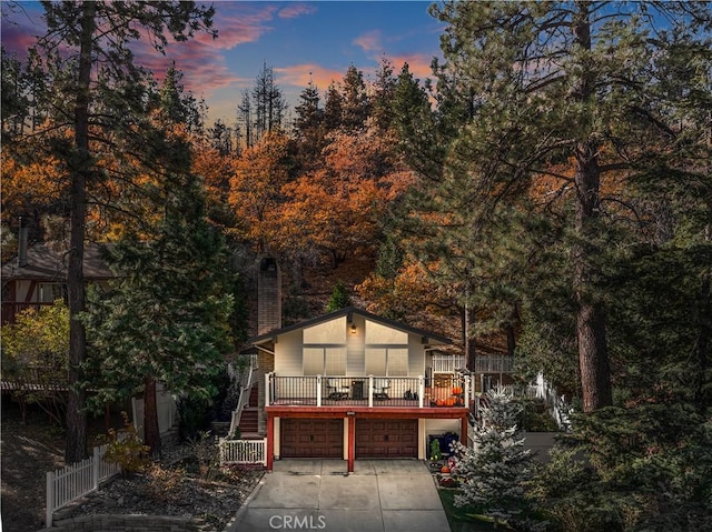 back house at dusk featuring a garage