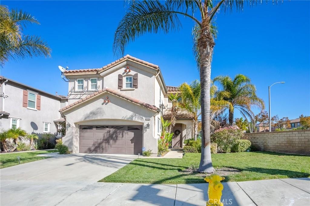 mediterranean / spanish-style house with a front yard and a garage