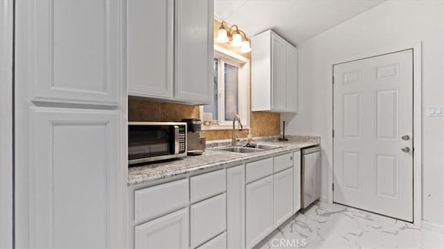 kitchen featuring sink, appliances with stainless steel finishes, tasteful backsplash, light stone counters, and white cabinetry