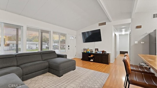 living room with lofted ceiling with beams and light hardwood / wood-style floors