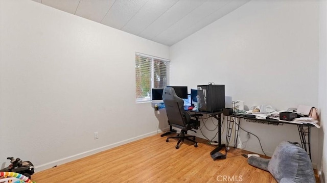 office space featuring wood-type flooring and vaulted ceiling