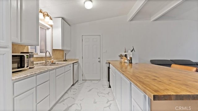 kitchen featuring sink, wooden counters, vaulted ceiling, white cabinets, and appliances with stainless steel finishes