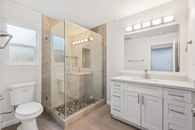 bathroom featuring tile patterned floors, an enclosed shower, vanity, and toilet