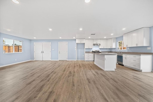 kitchen featuring a center island, sink, light hardwood / wood-style flooring, stainless steel appliances, and white cabinets