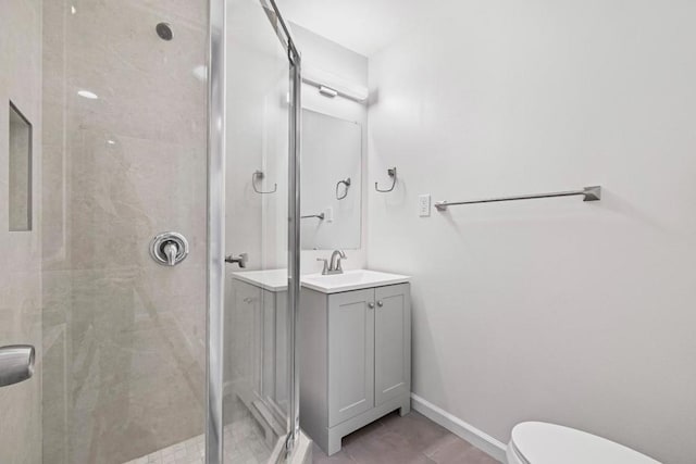 bathroom featuring a shower with shower door, toilet, and vanity