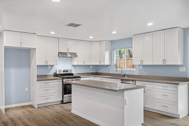 kitchen with sink, white cabinetry, stainless steel appliances, and a kitchen island