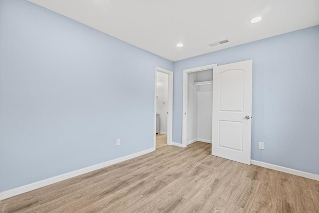 unfurnished bedroom featuring light wood-type flooring and a closet