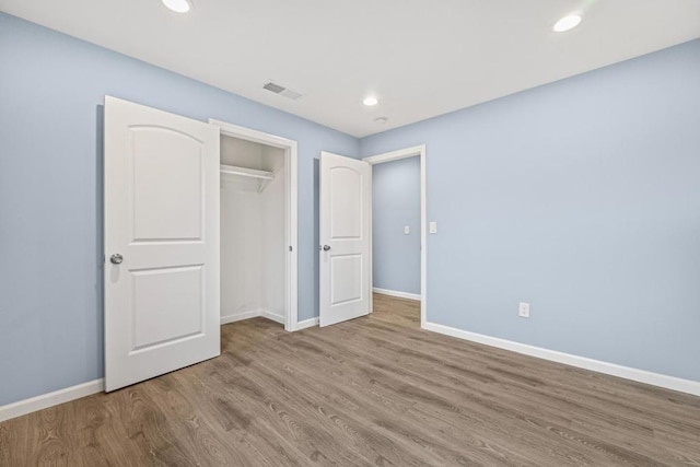 unfurnished bedroom featuring light wood-type flooring and a closet