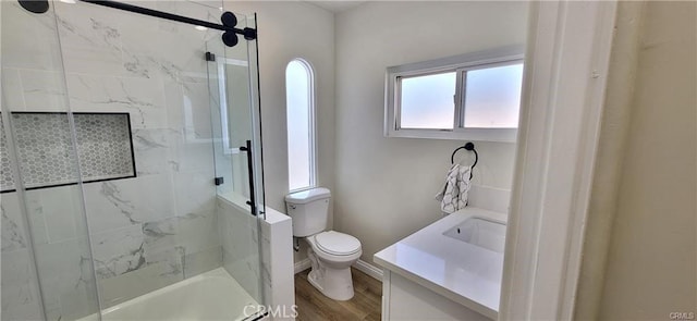 bathroom featuring hardwood / wood-style flooring, vanity, toilet, and walk in shower