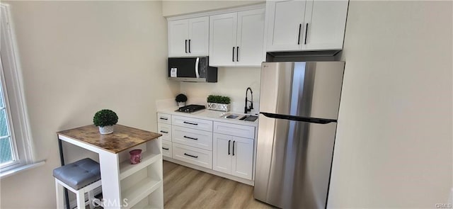 kitchen with light hardwood / wood-style floors, sink, white cabinetry, and stainless steel appliances