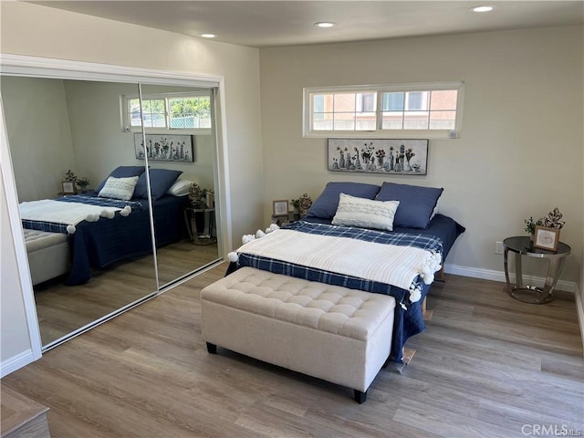 bedroom featuring multiple windows, a closet, and wood-type flooring