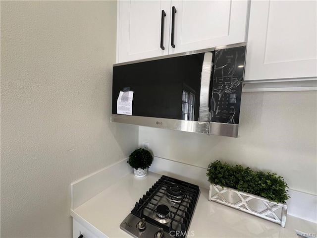 interior details featuring white cabinets and black gas cooktop