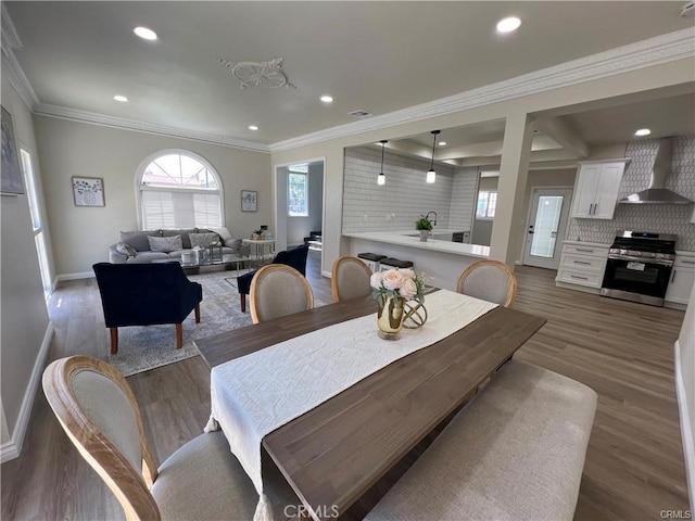 dining space with crown molding, sink, and dark hardwood / wood-style floors