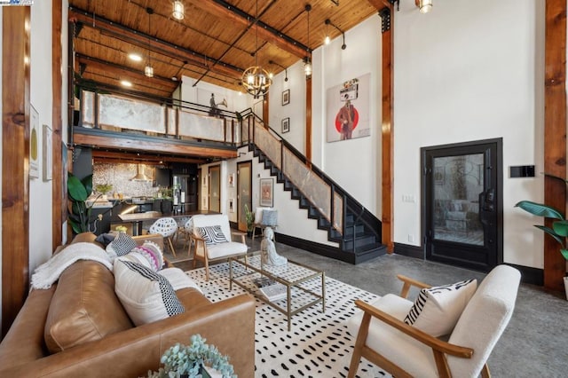 living room with beamed ceiling, a high ceiling, a chandelier, and wooden ceiling