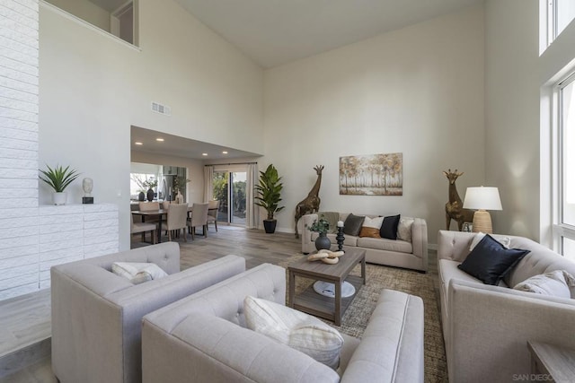 living room featuring a high ceiling and light hardwood / wood-style flooring