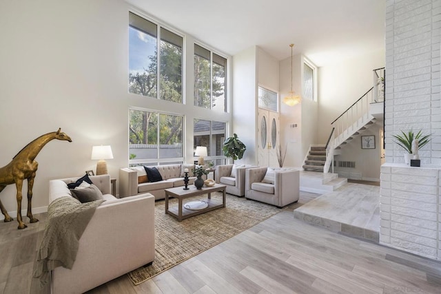 living room featuring light wood-type flooring and a high ceiling