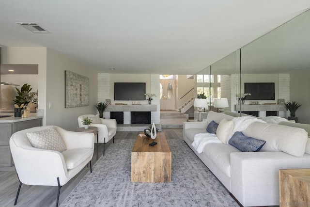 living room with light wood-type flooring and a large fireplace