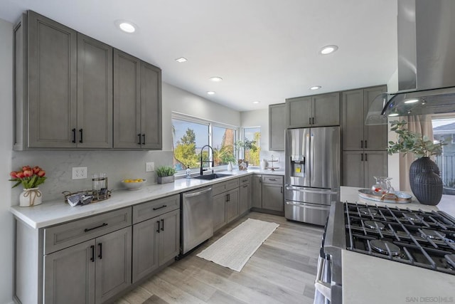 kitchen with stainless steel appliances, sink, backsplash, ventilation hood, and light wood-type flooring