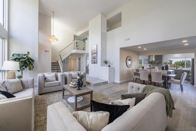 living room with a towering ceiling and light hardwood / wood-style floors