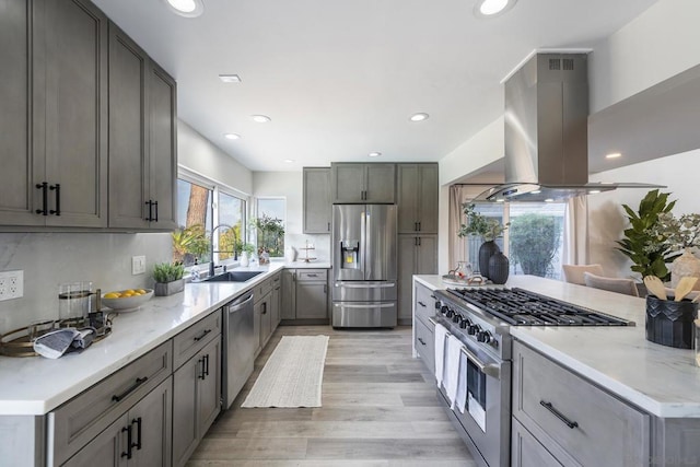 kitchen with gray cabinets, a wealth of natural light, sink, appliances with stainless steel finishes, and island range hood