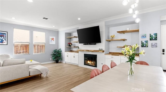 living room featuring light hardwood / wood-style floors and ornamental molding