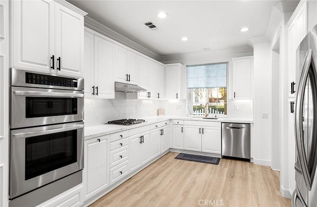 kitchen with white cabinetry, sink, light hardwood / wood-style flooring, crown molding, and appliances with stainless steel finishes