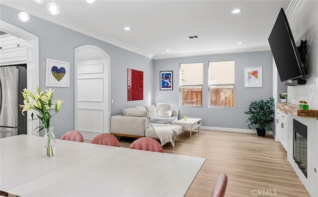 living room featuring ornamental molding and light wood-type flooring