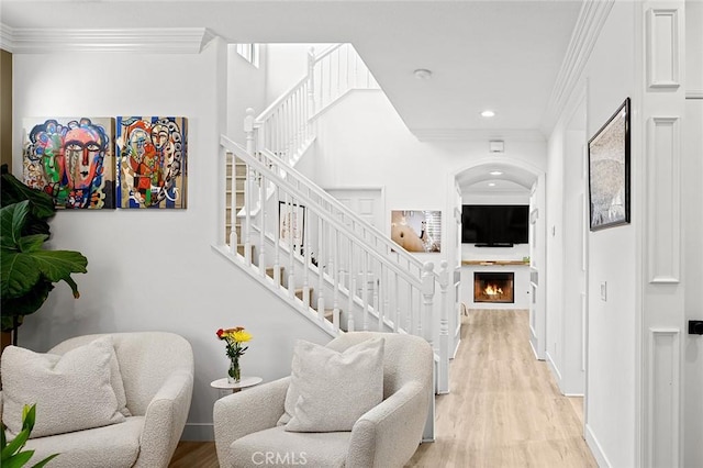 stairway featuring wood-type flooring and ornamental molding